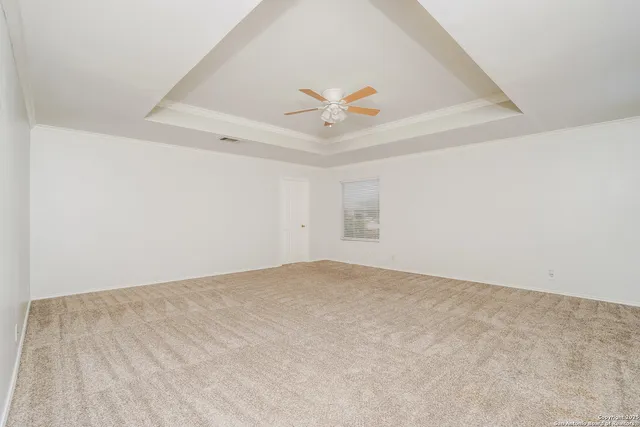 an empty room with a ceiling fan and wooden floor
