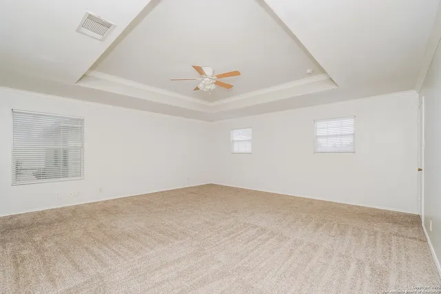 an empty room with fan and windows