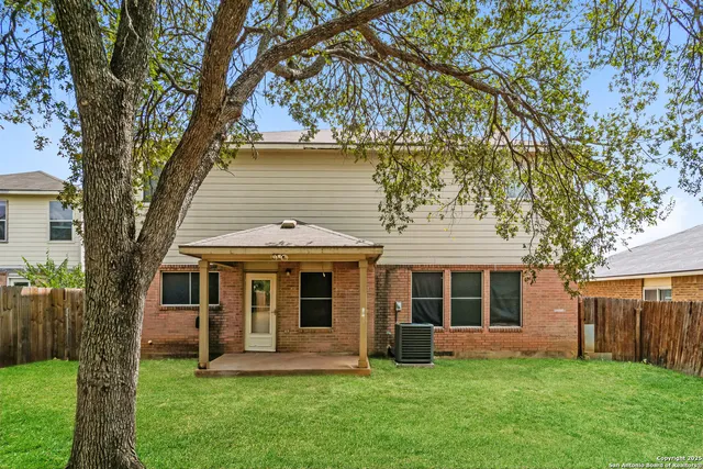 a front view of a house with a garden and trees