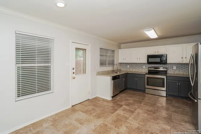 a kitchen with stainless steel appliances granite countertop a refrigerator sink and stove
