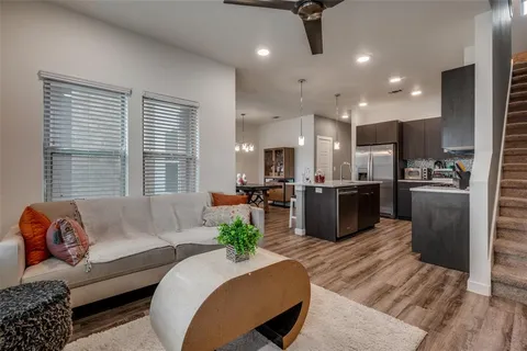 a kitchen with stainless steel appliances a sink dishwasher a refrigerator a microwave oven with cabinets and wooden floor