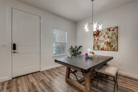 a living room with furniture floor to ceiling window hardwood floor and a flat screen tv