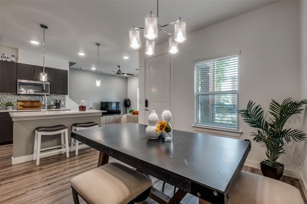 349 Tonga Street Dallas, TX 75203 - Photo 9 of 40 a kitchen with a table chairs a sink and dishwasher a refrigerator with wooden floor