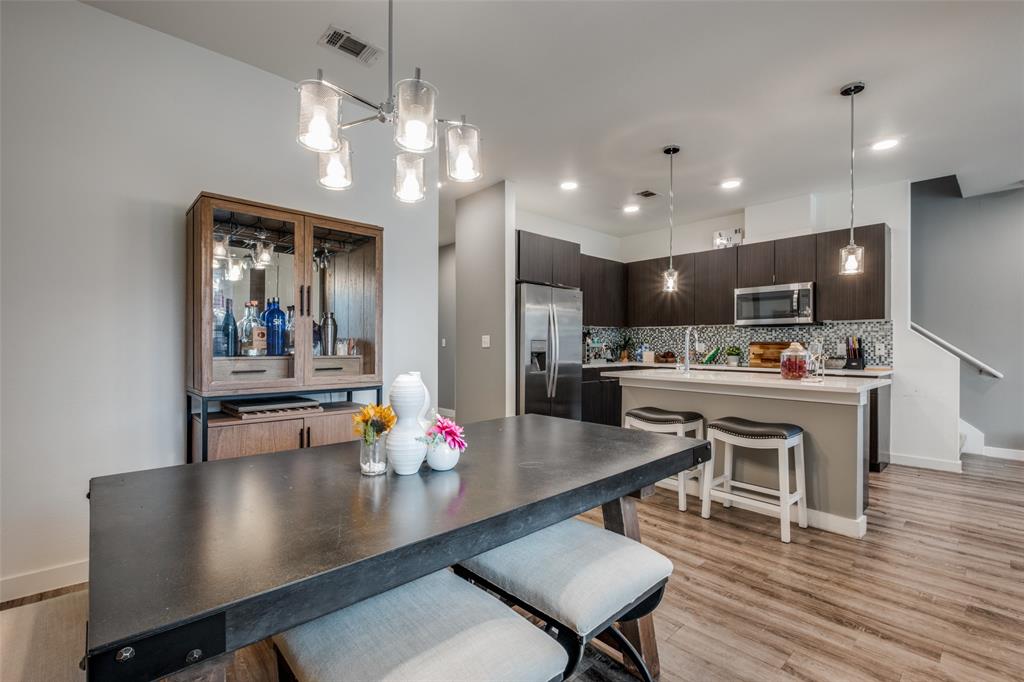 349 Tonga Street Dallas, TX 75203 - Photo 10 of 40 a kitchen with a dining table chairs refrigerator and microwave