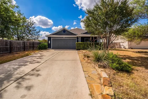 a front view of a house with a yard and trees
