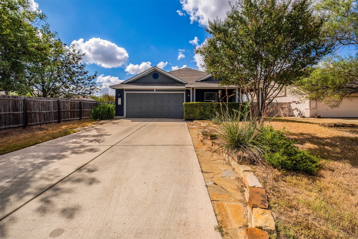 a front view of a house with a yard and trees