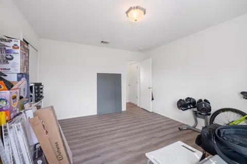 a kitchen with stainless steel appliances a refrigerator a sink dishwasher a stove and a dining table with wooden floor