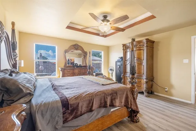 a bedroom with a bed wooden floor and ceiling fan