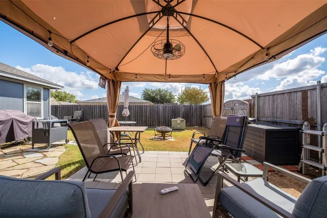 a view of a patio with table and chairs under an umbrella