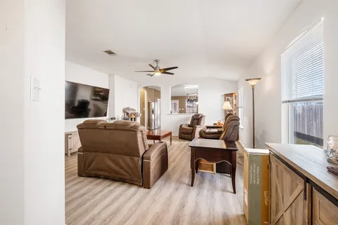 a living room with furniture flat screen tv and window