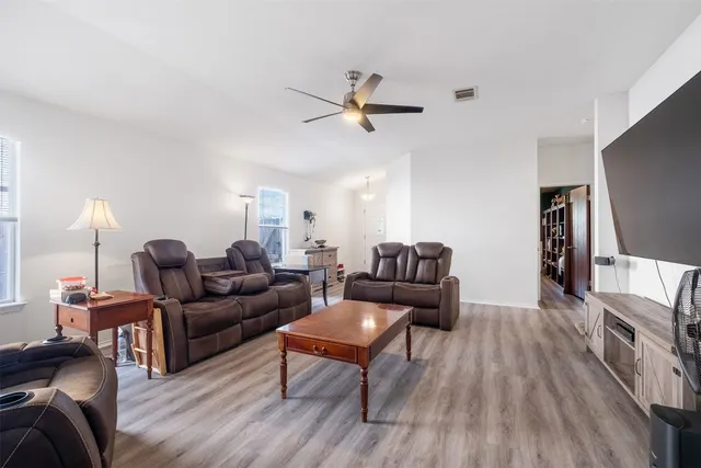 a living room with furniture and a wooden floor