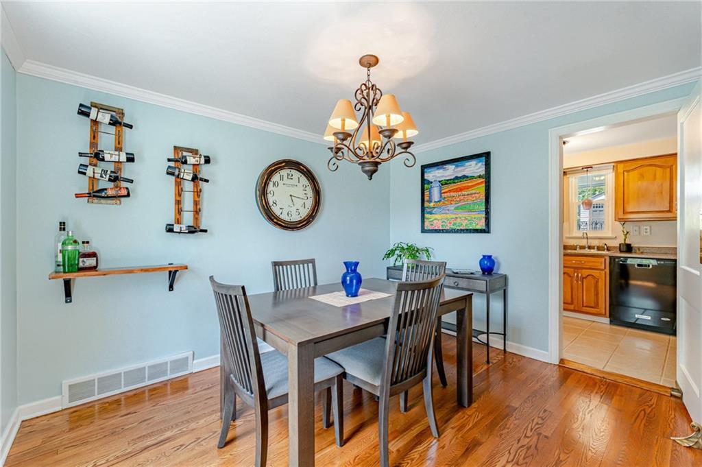 495 Old Farm Road Pittsburgh, PA 15228 - Photo 5 of 25 a view of a dining room and kitchen with furniture wooden floor and a clock