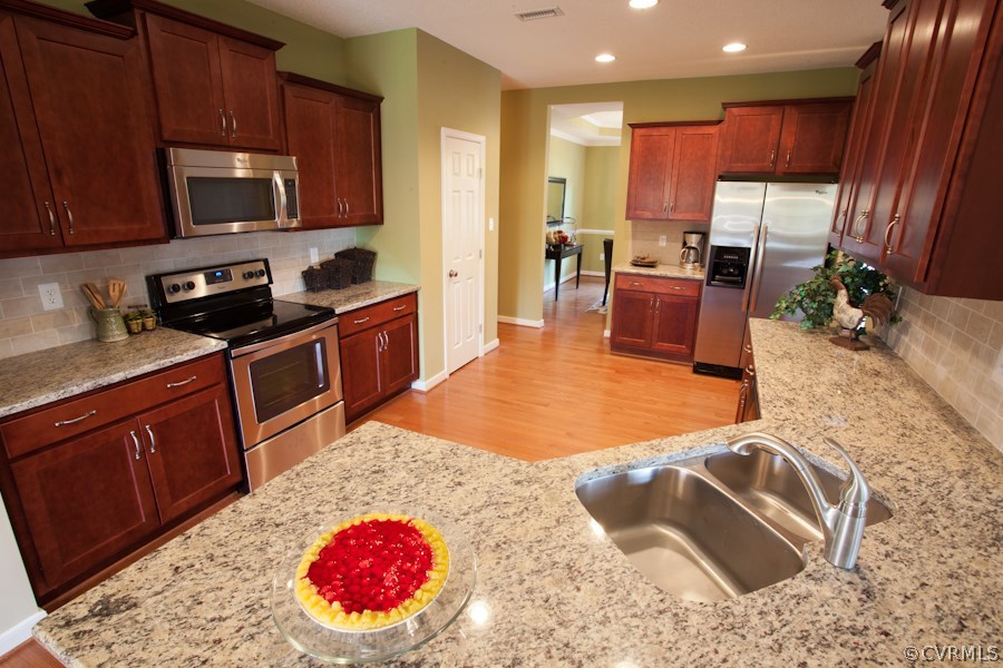 11400 Avening Road Midlothian, VA 23112 - Photo 6 of 10 a kitchen with stainless steel appliances granite countertop a stove refrigerator sink and cabinets