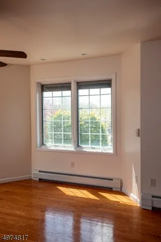 a view of a livingroom with wooden floor and a window