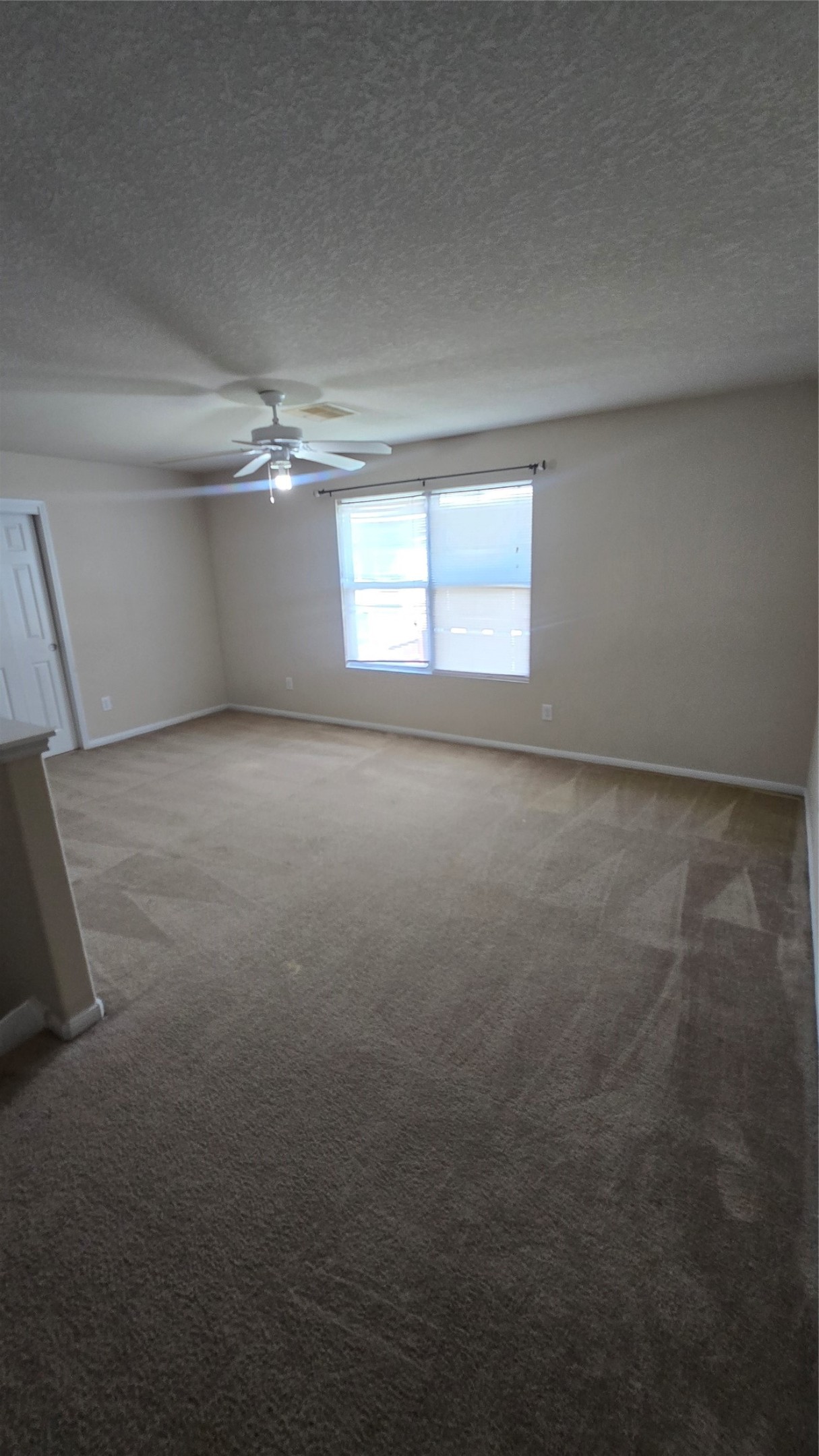 14819 Isle Of Pines Court Houston, TX 77049 - Photo 8 of 14 an empty room with windows and chandelier fan