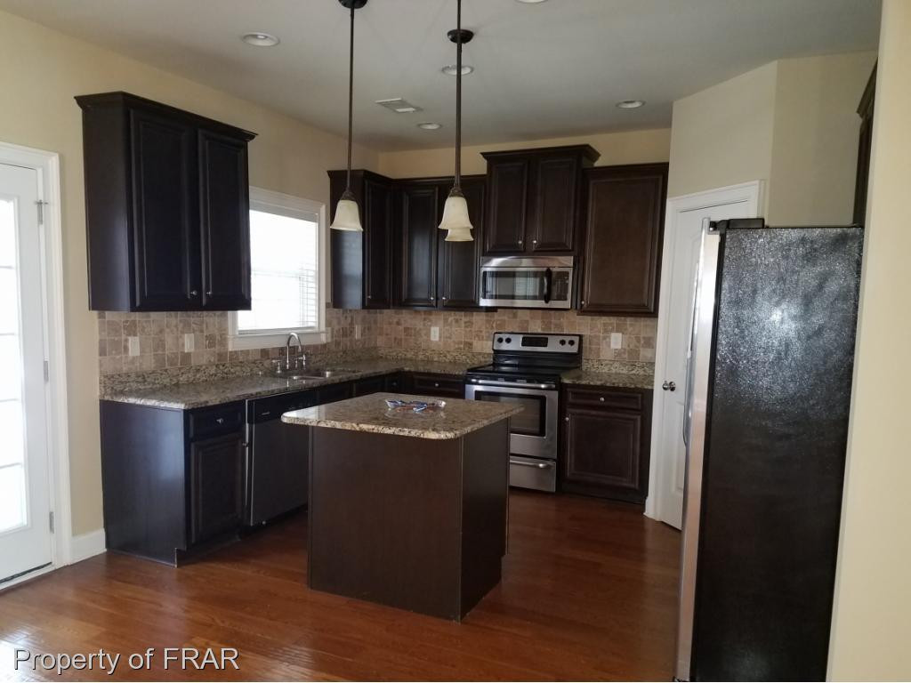 355 Regimental Drive Cameron, NC 28326 - Photo 5 of 19 a kitchen with stainless steel appliances granite countertop a refrigerator a stove a sink and a microwave