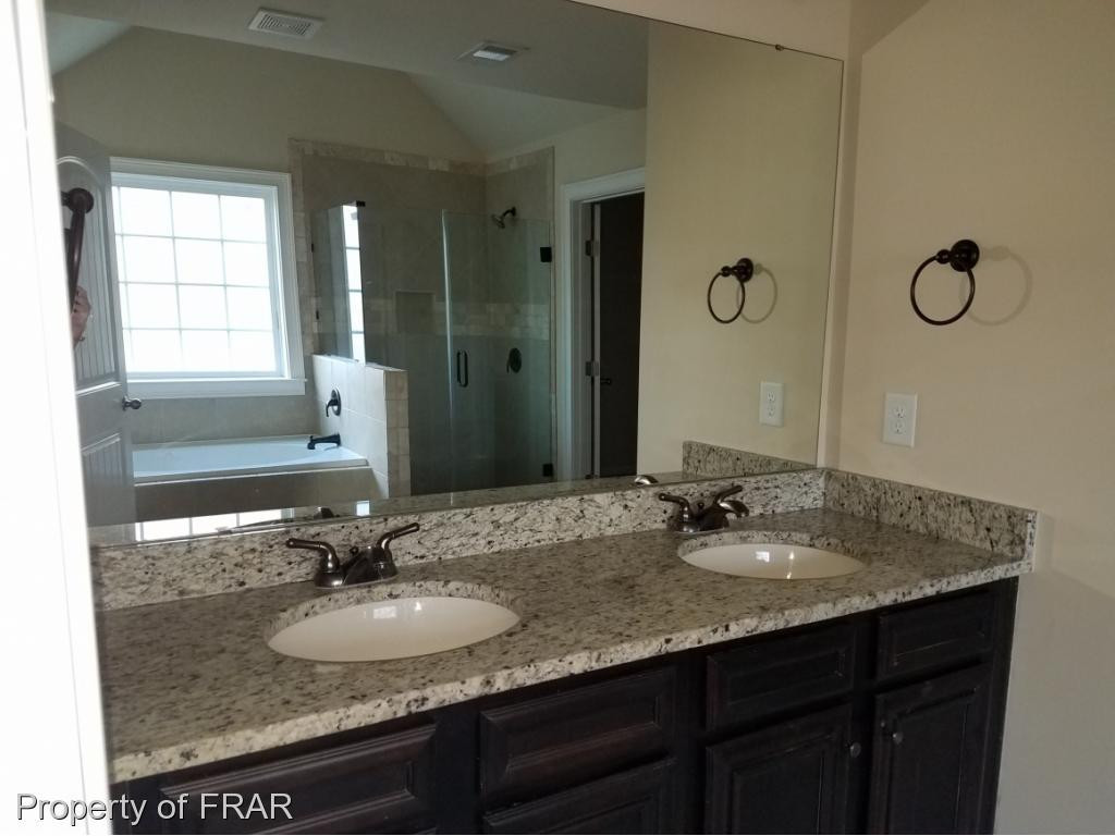 355 Regimental Drive Cameron, NC 28326 - Photo 10 of 19 a bathroom with a granite countertop sink a mirror and double