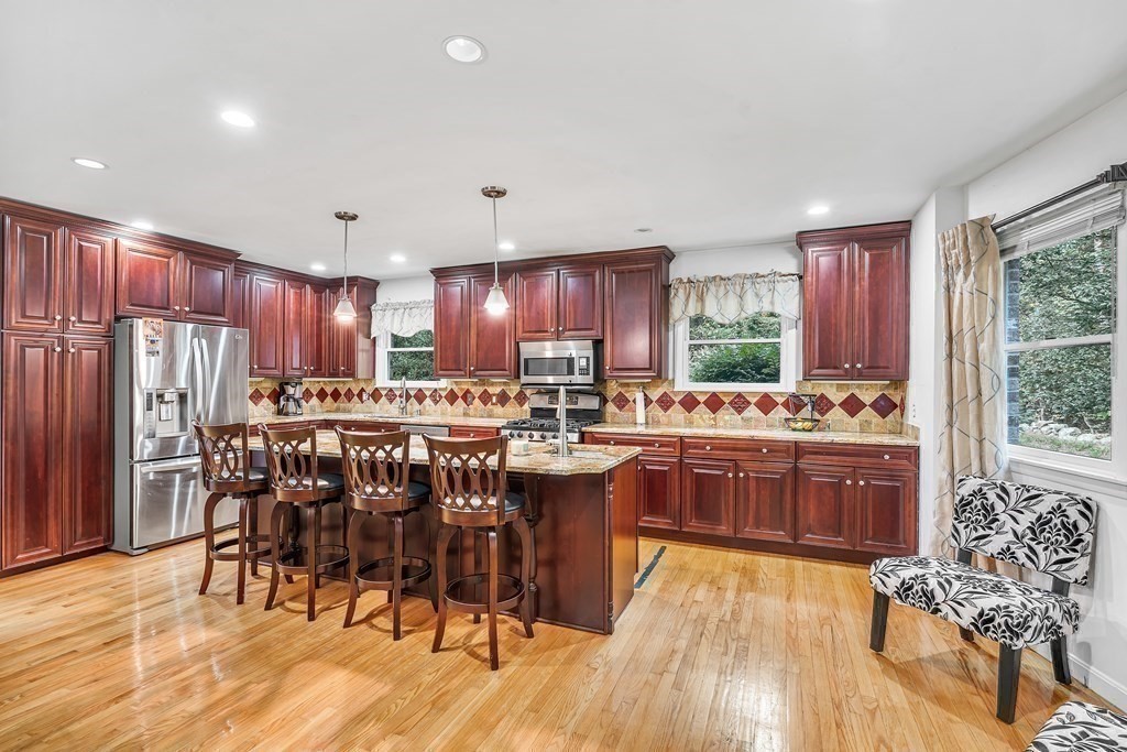 3 Goodnow Road Sudbury, MA 01776 - Photo 4 of 34 a kitchen with stainless steel appliances granite countertop a table chairs sink refrigerator and cabinets
