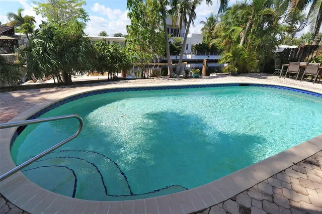 a front view of a house with a yard and potted plants