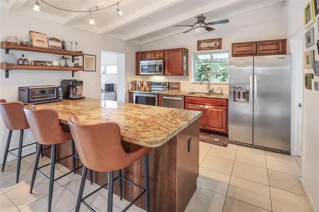 a kitchen with kitchen island a counter top space appliances and a center island