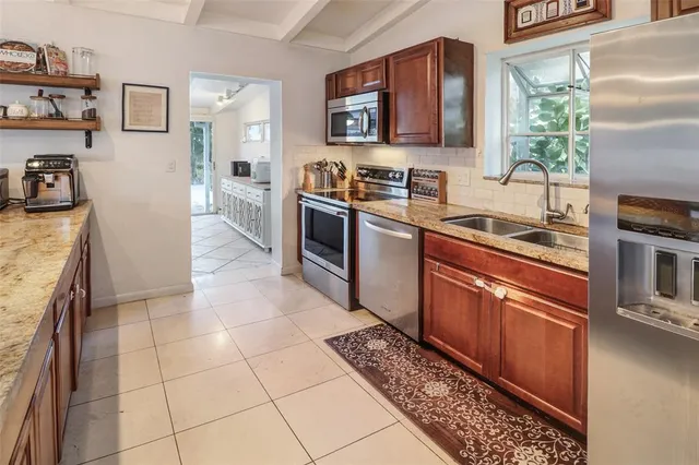 a kitchen with stainless steel appliances granite countertop a stove a sink and a microwave