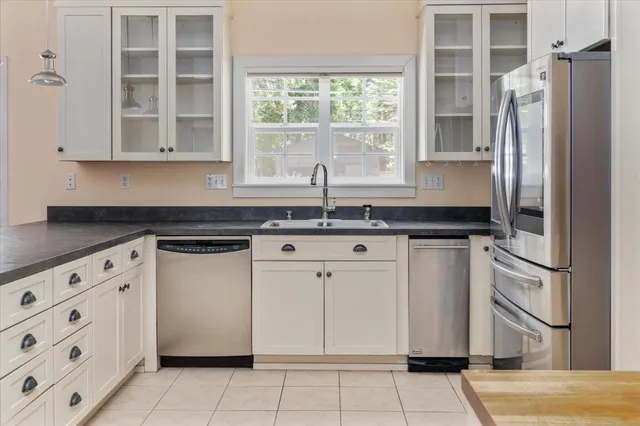 a kitchen with stainless steel appliances granite countertop a sink and a refrigerator