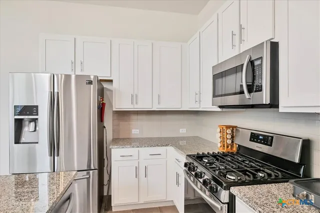 a kitchen with stainless steel appliances granite countertop a stove and a refrigerator