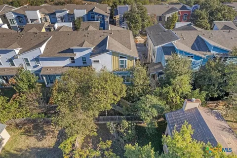 an aerial view of residential houses with outdoor space and lake view