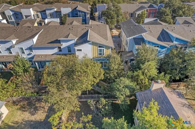 an aerial view of residential houses with outdoor space and lake view