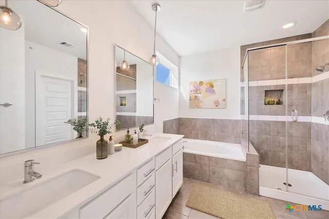 a bathroom with a tub sink and mirror