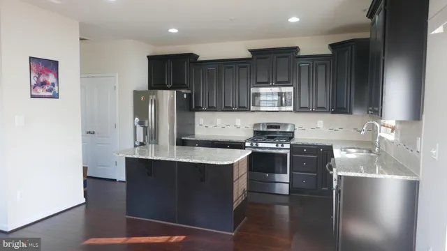 a kitchen with stainless steel appliances granite countertop a stove refrigerator sink and cabinets