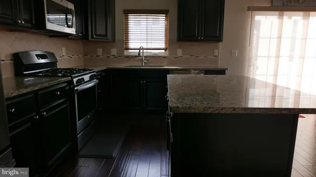 a kitchen with a sink a stove and cabinets