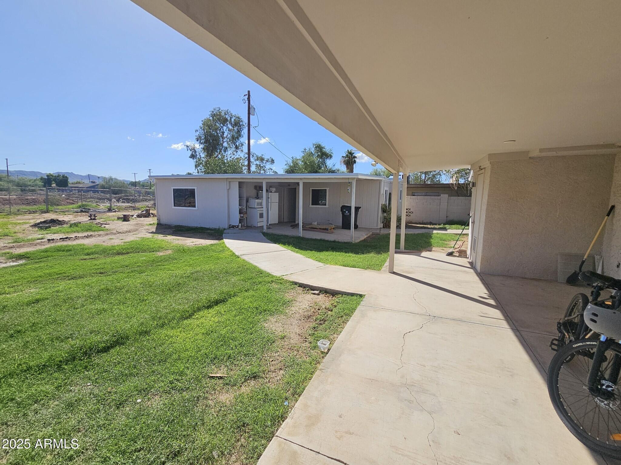 819 East Apollo Road Phoenix, AZ 85042 - Photo 14 of 17 a view of a house with a yard and sitting area