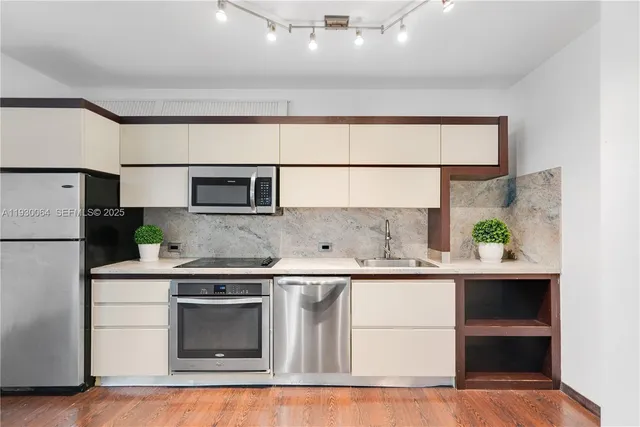 a kitchen with stainless steel appliances a refrigerator sink and cabinets