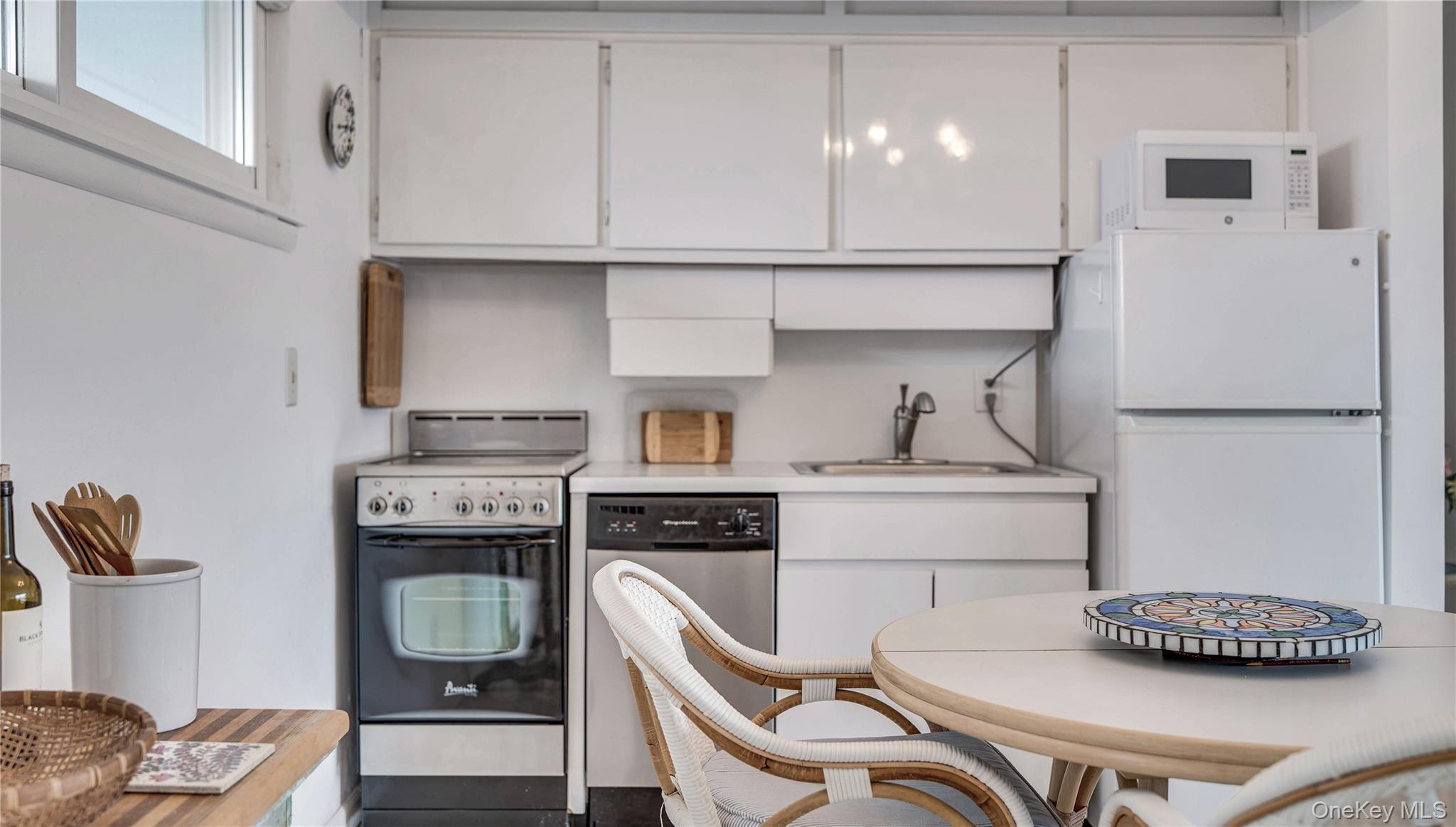 281 Dune Road, Unit 2A Westhampton Beach, NY 11978 - Photo 9 of 19 a kitchen with stainless steel appliances a refrigerator and a stove top oven