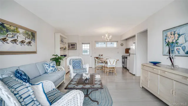 a living room with furniture and a dining table with kitchen view