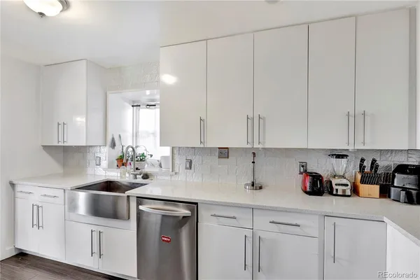 a kitchen with white cabinets and white appliances