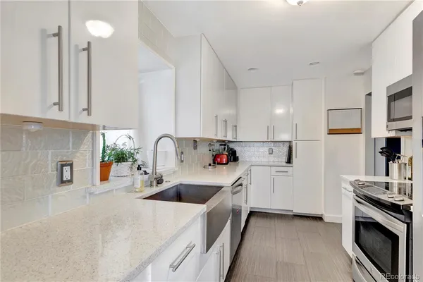 a kitchen with white cabinets and sink