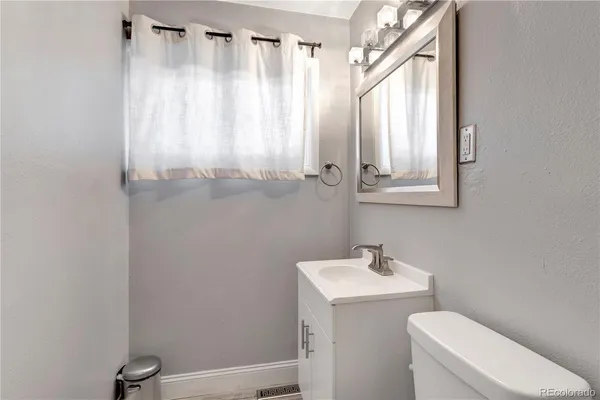 a bathroom with a sink a toilet and a mirror