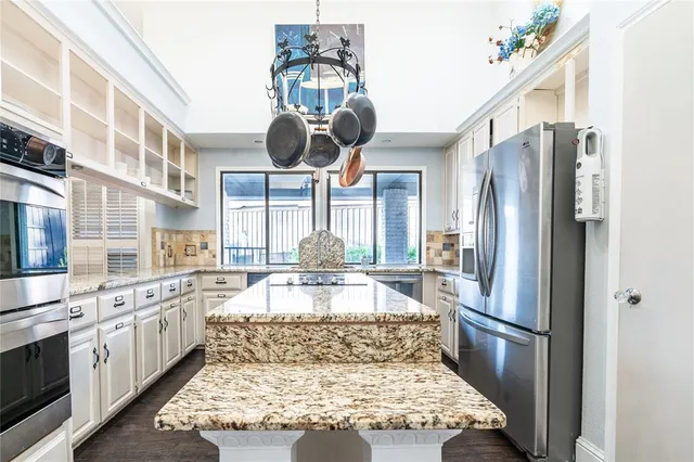 a large kitchen with kitchen island granite countertop a large counter top and stainless steel appliances