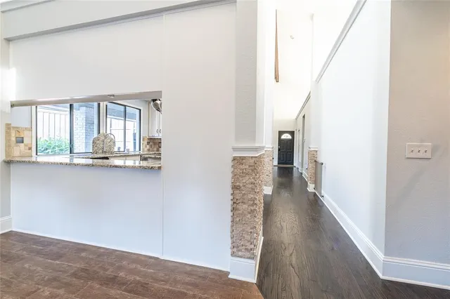 a view of a hallway with wooden floor and staircase
