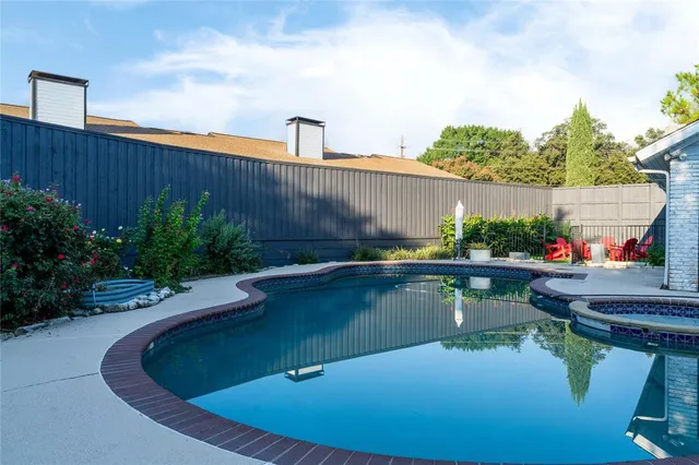 a view of a swimming pool with a yard and plants