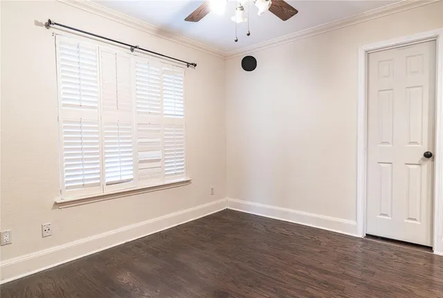 an empty room with a window and wooden floor