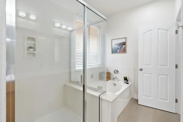 a bathroom with a bathtub a shower and a sink