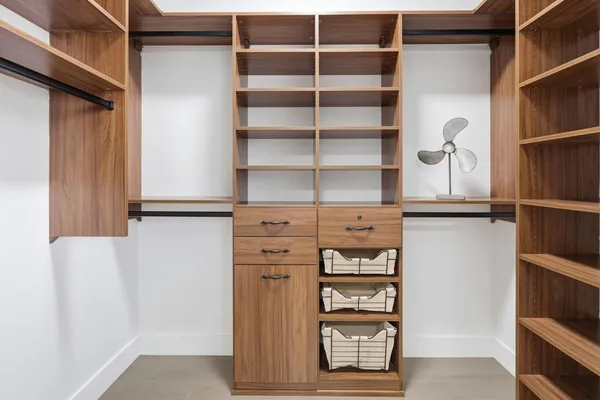 a view of walk in closet with empty racks