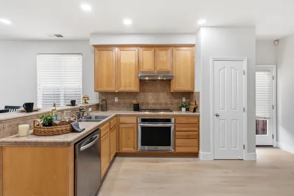 a kitchen with stainless steel appliances granite countertop a stove a sink and a refrigerator