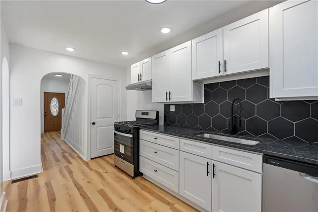 a kitchen with granite countertop a sink and cabinets