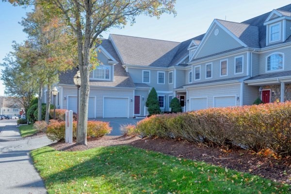 117 Tamarack Lane, Unit 117 Abington, MA 02351 - Photo 2 of 26 a front view of a house with a garden and plants