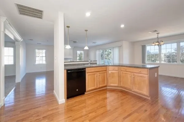a large kitchen with granite countertop a large counter top space a sink stainless steel appliances and cabinets