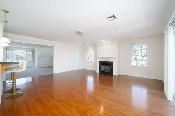 a view of a livingroom with wooden floor and a fireplace